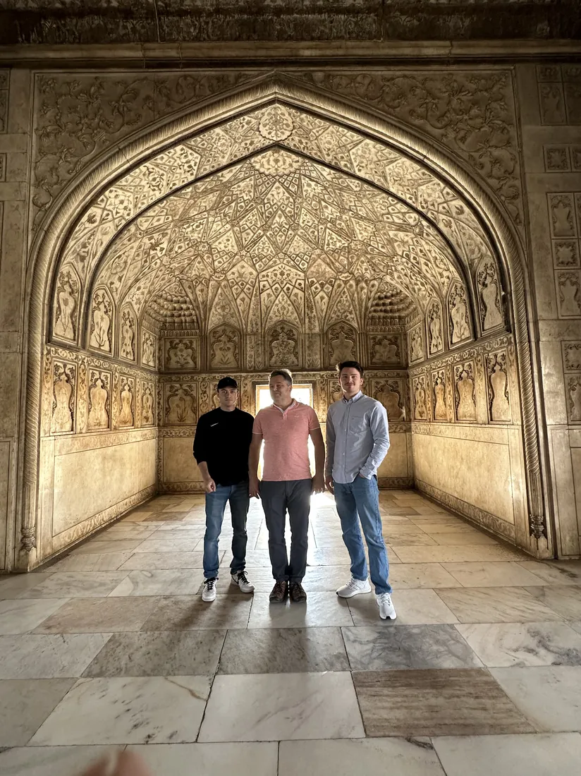 Guests under an ornate arch at Agra Fort